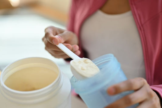 Young Mother Adding Protein Powder Into A Cup